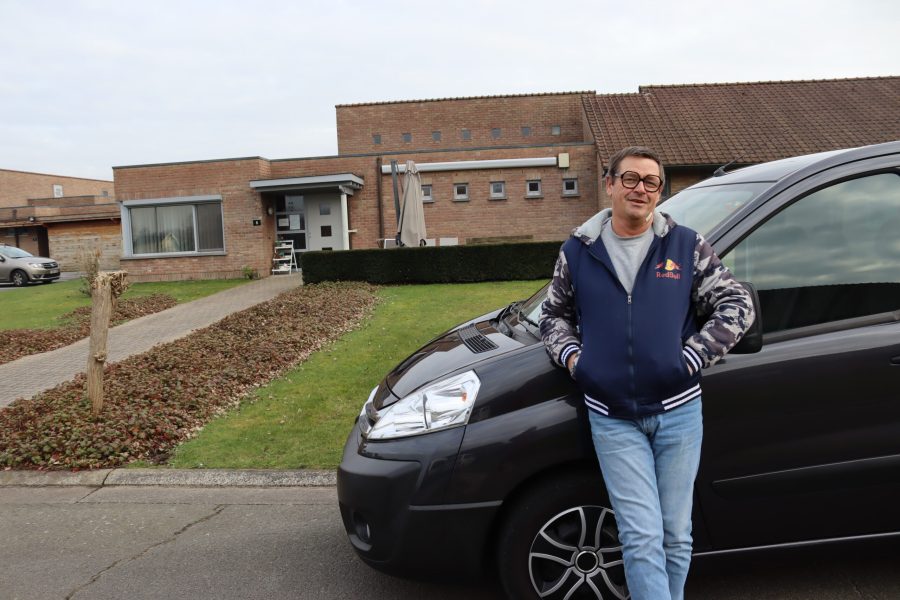 chauffeur op de voorgrond met De Vierklaver Adegem op de achtergrond